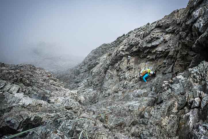 Rock climbing in mountains with a guide